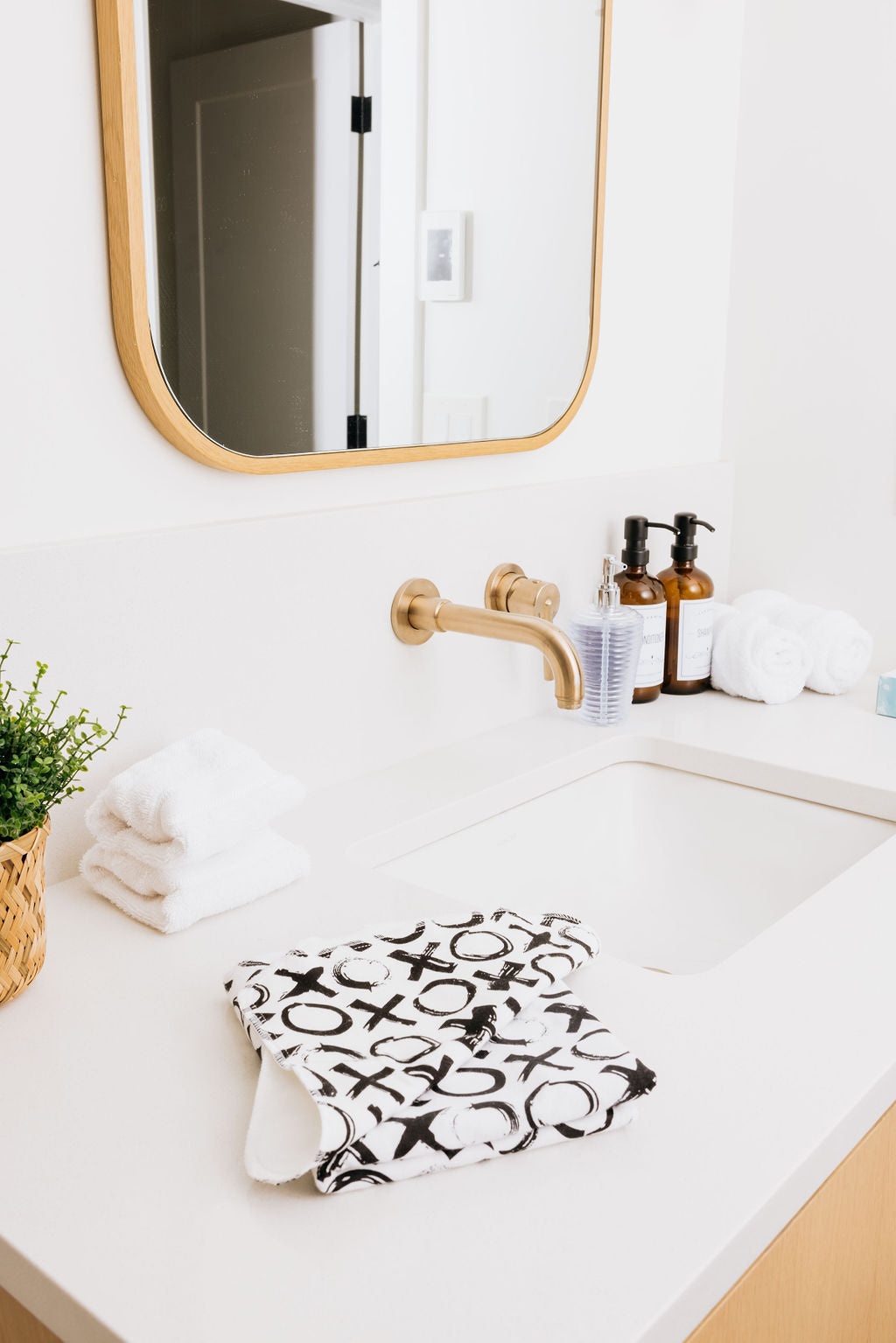 Bathroom vanity with a folded XO Oneberrie washcloth by the sink