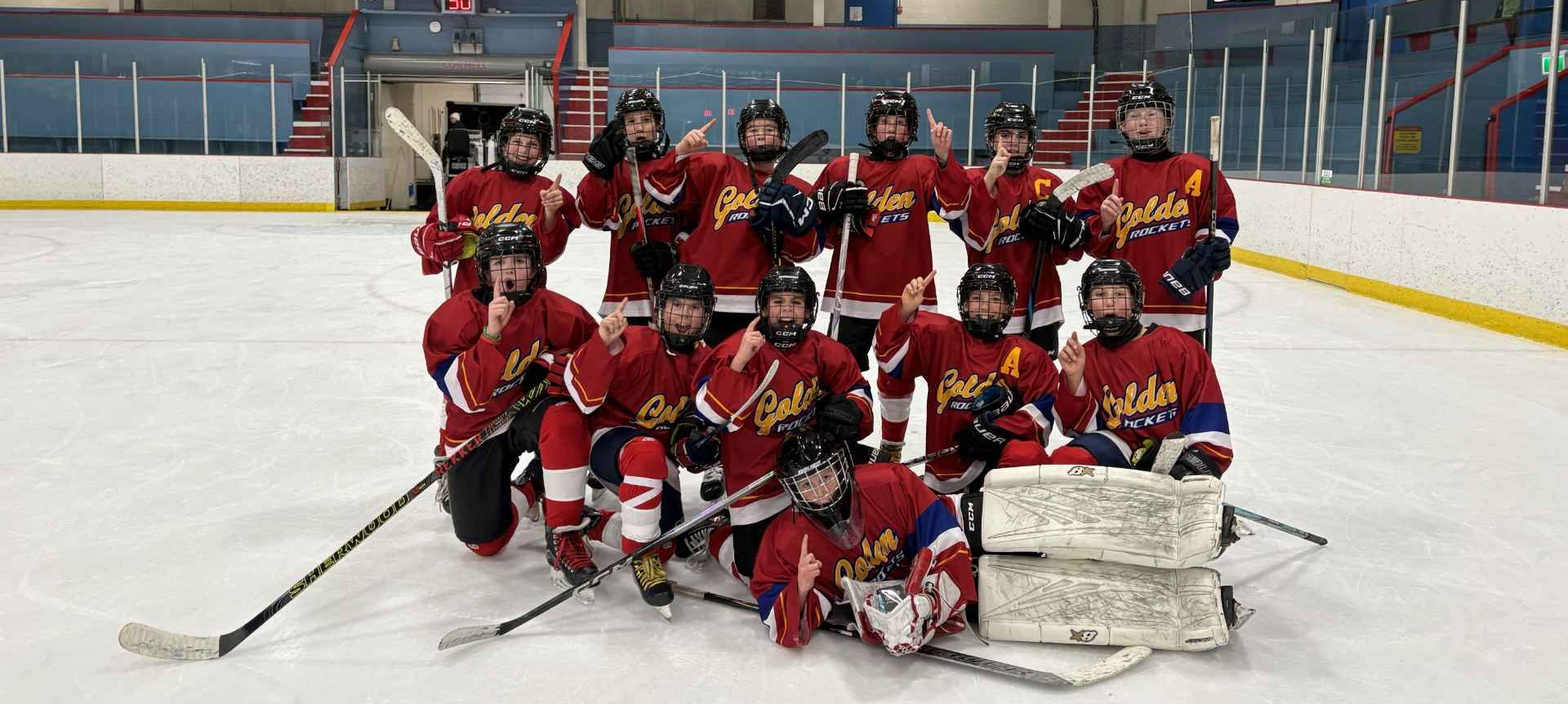 Ice hockey team posing for a photo on an indoor ice rink