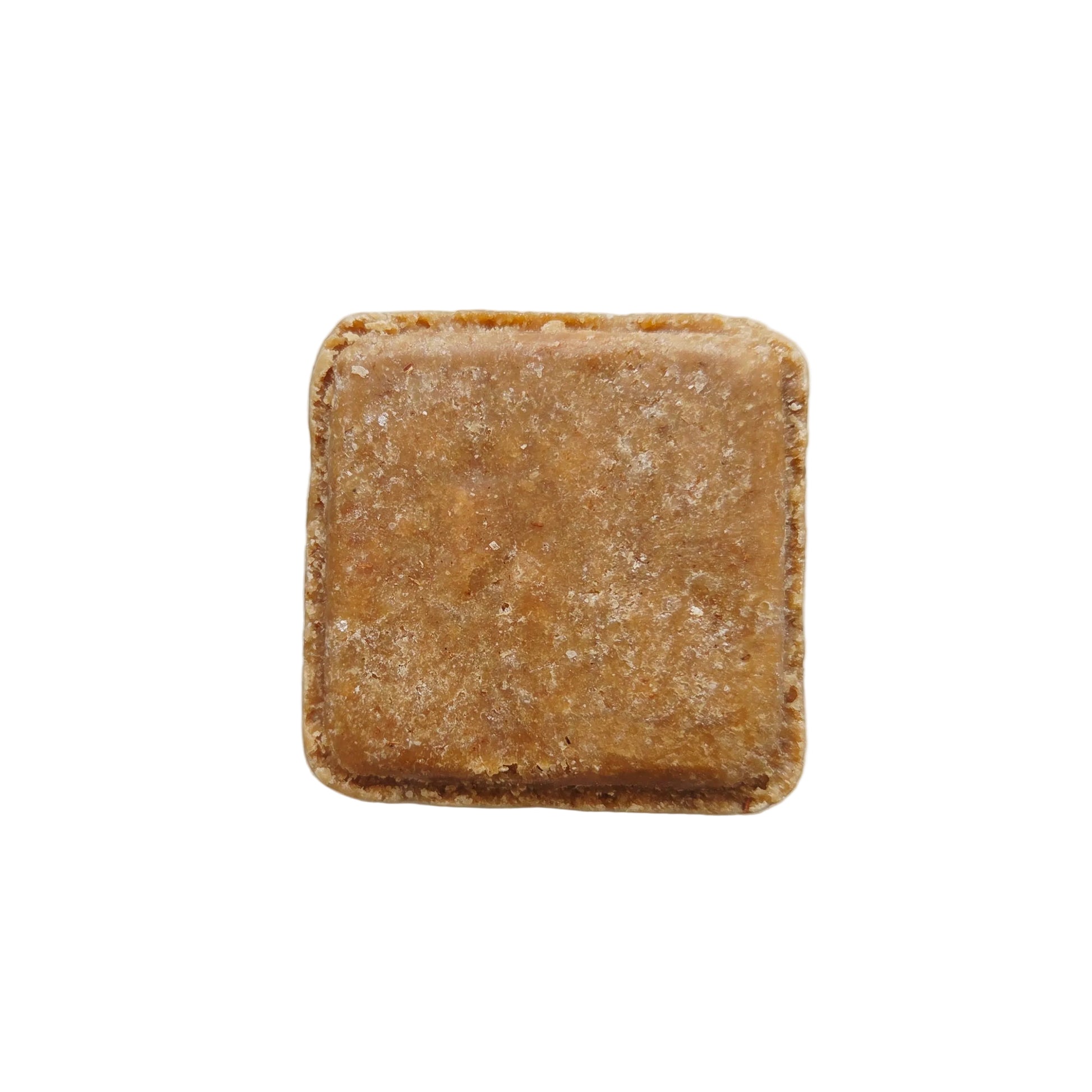 A single square, light brown, textured bar of Bare. shampoo block centered on a plain white background.