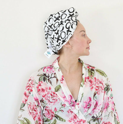 Woman in a floral robe wearing an Oneberrie Hair Wrap Towel in bold black brushstroke XO print, side profile