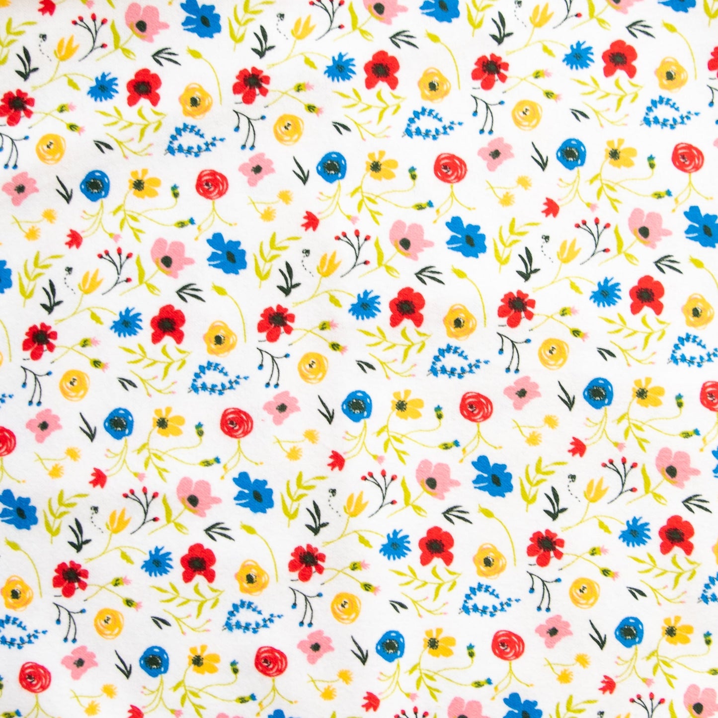 Oneberrie Hair Wrap Towel fabric close-up in wildflower print with red, blue, yellow and pink flowers on white