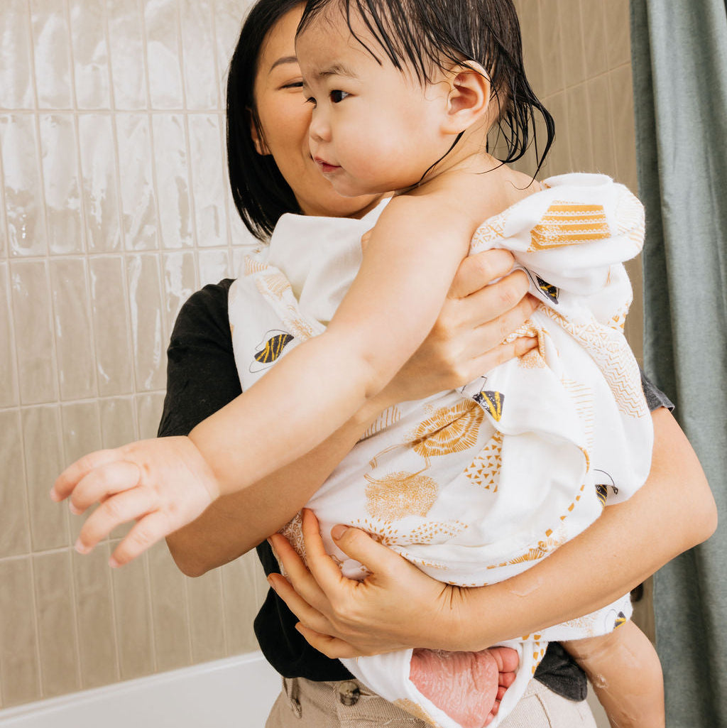 Woman holding a child in a bathroom