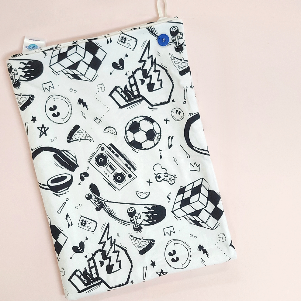 A soft baby towel with a black retro boy pattern which includes a skull, soccer ball, cassette player, skateboard and rubix cube.