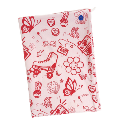 A soft baby towel with a red retro print of hearts, butterflies, rollerskates, flowers and a cassette tape on a pink background 