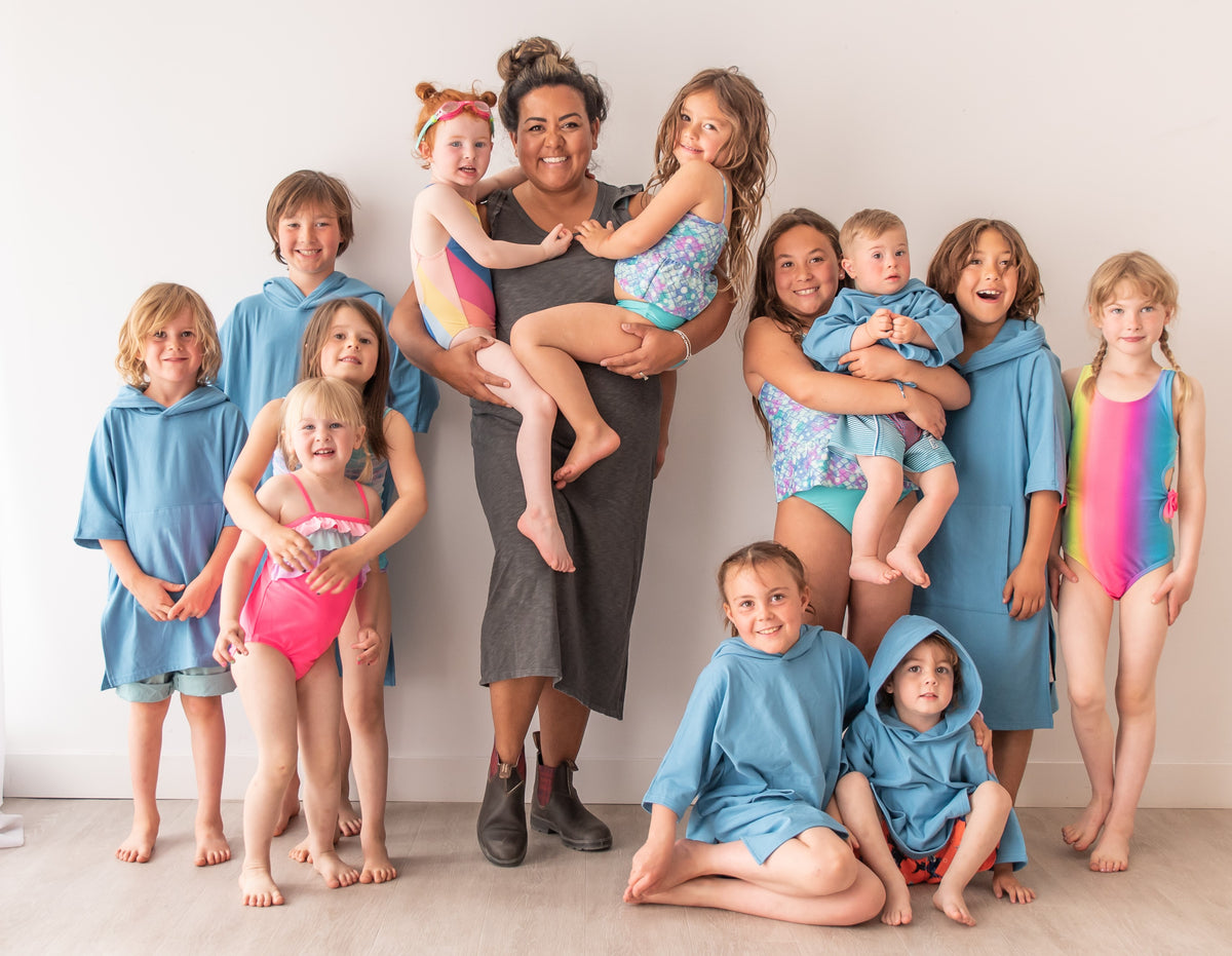 Sue-Rose with many children wearing blue Oneberrie hooded towels