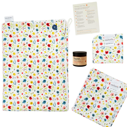 wildflower patterned set on a white background. Set includes towel, washcloth, swaddle, 2oz lotion and card. wild flowers are red, blue, yellow, pink and green detail. 