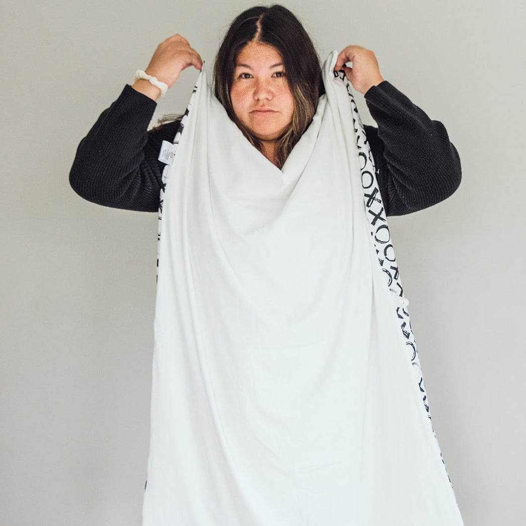 Woman holding up a Oneberrie towel before fastening around her neck