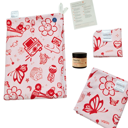 Retro red and white patterned set on a white background. Set includes towel, washcloth, swaddle, 2oz lotion and card. Retro print includes polaroid camera, butterfly, gumball machine and cupcake. 