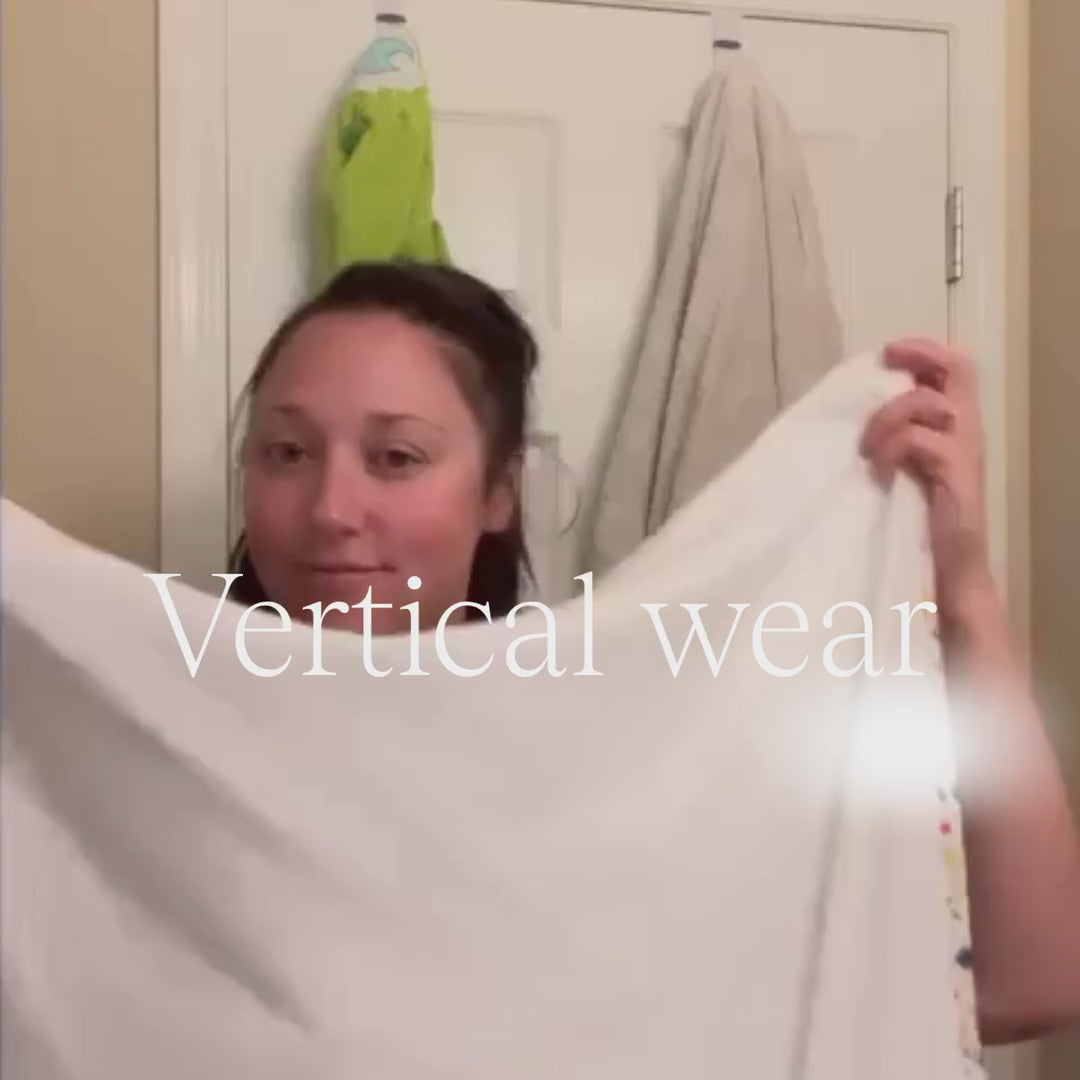 Mom bathing her newborn in the bathroom putting the towel on vertically.
